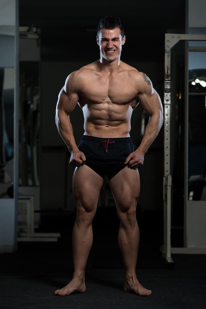 Portret młodego mężczyzny sprawnego fizycznie, pokazujący jego dobrze wyszkolone ciało, muskularny, lekkoatletyczny kulturysta Model Fitness pozowanie po ćwiczeniach