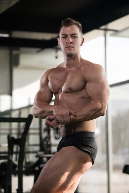 Portret młodego mężczyzny sprawnego fizycznie, pokazujący jego dobrze wyszkolone ciało, muskularny, lekkoatletyczny kulturysta Model Fitness pozowanie po ćwiczeniach