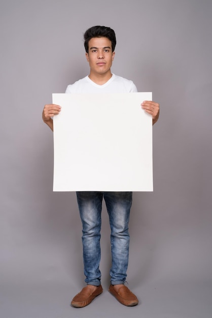 Portret młodego mężczyzny stojącego na białym tle