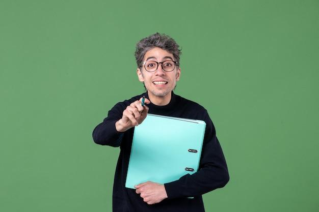portret młodego mężczyzny trzymającego dokumenty studio strzał na zielonym tle lekcja pracy nauczyciela