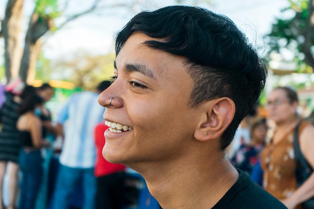 Portret młodego mężczyzny z łaciny uśmiechającego się i bawiącego się w parku