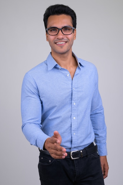Portret młodego przystojnego indyjskiego biznesmena na białym tle