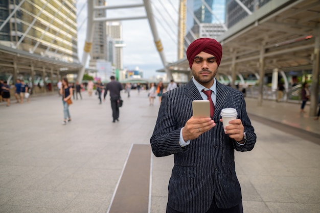 Portret Młodego Przystojnego Indyjskiego Biznesmena Sikhów W Turbanie Podczas Zwiedzania Miasta Bangkok, Tajlandia