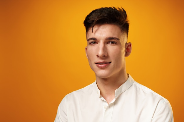 Portret młodego przystojnego mężczyzny nastolatka na żółtej powierzchni