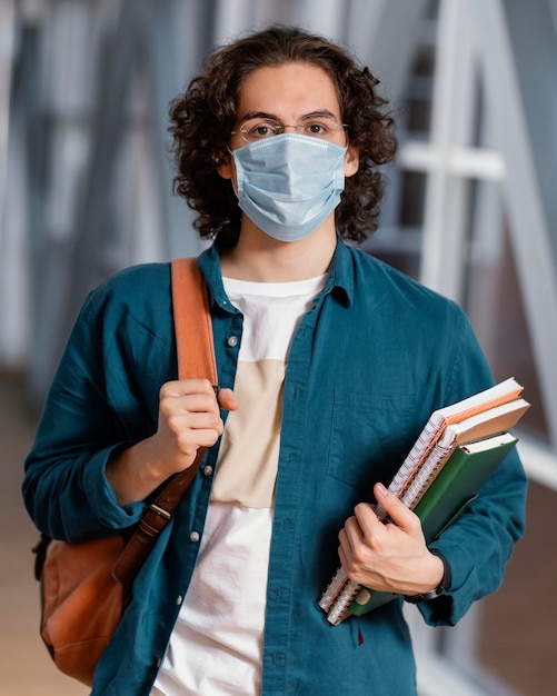 Zdjęcie portret młodego studenta na sobie maskę medyczną