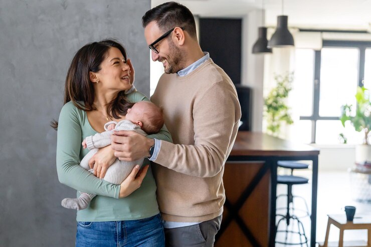 Zdjęcie portret młodego szczęśliwego mężczyzny i kobiety trzymających nowo narodzone urocze dziecko ubrane w białe ubrania unisex