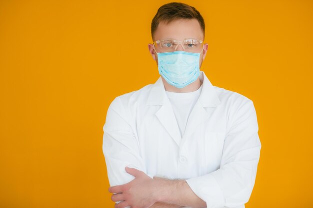 Portret młodego wyczerpanego lekarza w niebieskiej masce medycznej na twarzy Zapobieganie koronawirusowi nCov19