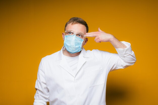 Portret młodego wyczerpanego lekarza w niebieskiej masce medycznej na twarzy