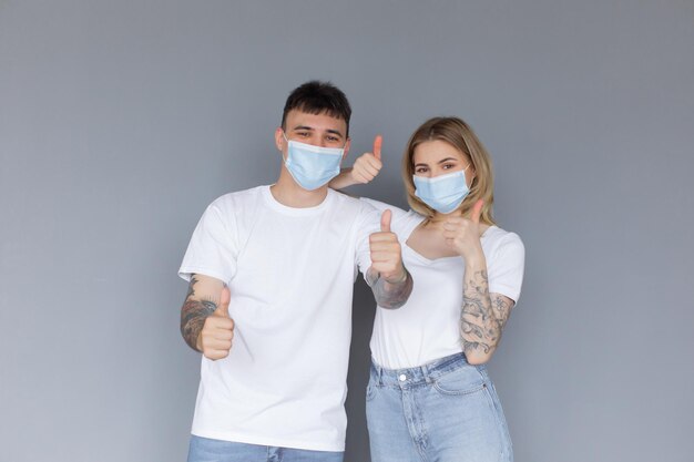 Portret młodej atrakcyjnej pary rodzinnej z chirurgiczną maską medyczną stojącą razem