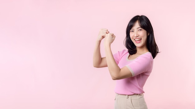 Portret młodej azjatyckiej kobiety dumnej i pewnej siebie, pokazującej silną siłę mięśni, zgięte ramiona, pozowanie, czuje się o swoim sukcesie równouprawnienie kobiet, zdrowa siła i koncepcja odwagi