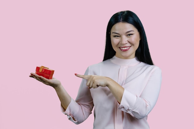 Portret młodej azjatyckiej kobiety wskazuje na czerwone pudełko