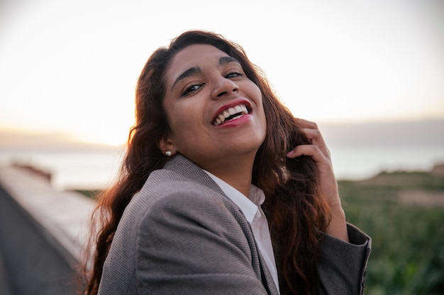 Portret młodej bizneswoman Hispanic uśmiecha się podczas zachodu słońca