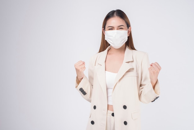 Portret młodej bizneswoman noszącej maskę chirurgiczną na białym tle studio
