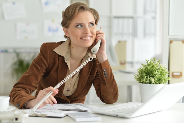 Portret młodej bizneswoman rozmawiającej przez telefon w biurze