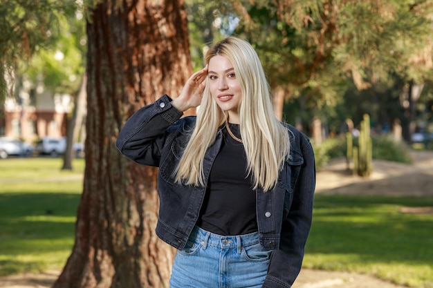 Portret Młodej Blondynki Rozciągającej Włosy I Uśmiechającej Się Do Kamery