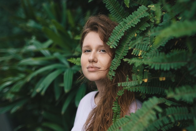 Portret młodej dziewczyny na zielonym tle naturalnym ekologiczna kobieta w tropikalnym parku lub dżungli pozytywna dama lubi spacerować w letni dzień