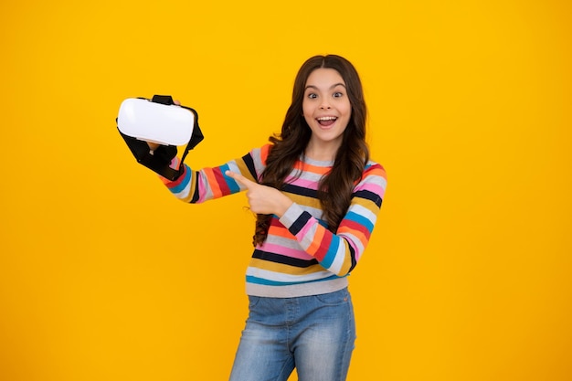 Portret młodej dziewczyny nastolatki w kasku VR na żółto Gracz grający w gry VR Gry VR Szczęśliwa nastolatka pozytywne i uśmiechnięte emocje nastoletniej dziewczyny