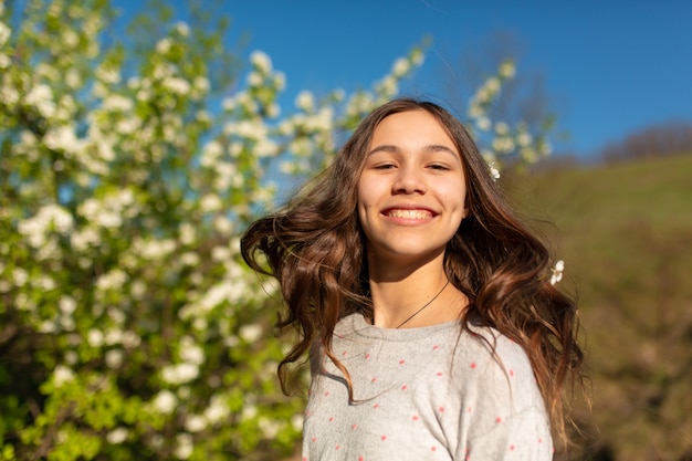 Portret młodej dziewczyny piękne nastolatki w kwitnących wiosną zielony ogród.