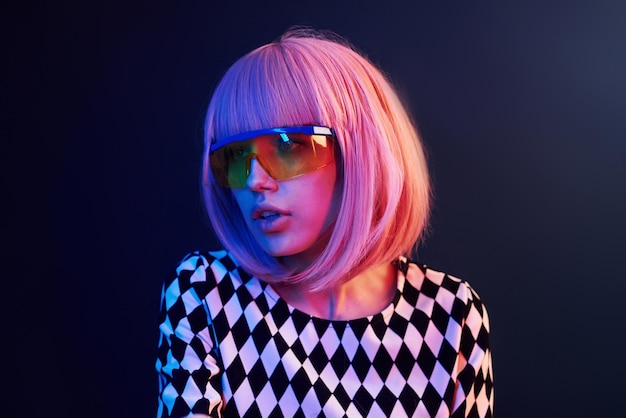 Portret młodej dziewczyny z blond włosami w okularach w czerwonym i niebieskim neonu w studio