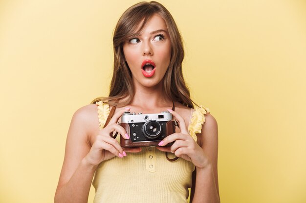 Portret młodej dziewczyny, zaskoczony, trzymając aparat fotograficzny