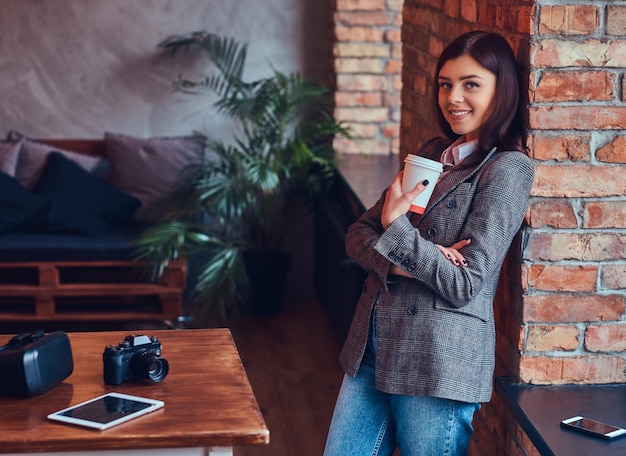 Portret młodej fotografki trzyma filiżankę poranka