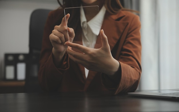 Portret młodej kobiety Azji freelancer ręka pracuje na tablecie komputerowym w nowoczesnym biurze Robi raport analizy rachunkowości dane inwestycji w nieruchomości Koncepcja systemów finansowych i podatkowych