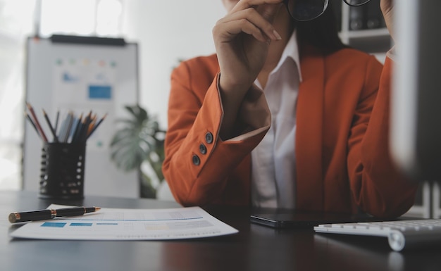 Portret młodej kobiety Azji freelancer ręka pracuje na tablecie komputerowym w nowoczesnym biurze Robi raport analizy rachunkowości dane inwestycji w nieruchomości Koncepcja systemów finansowych i podatkowych