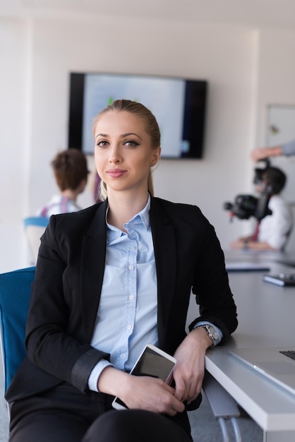 Portret Młodej Kobiety Biznesu W Nowoczesnym Wnętrzu Biura Startupowego, W Tle Zespół W Grupie Spotkań