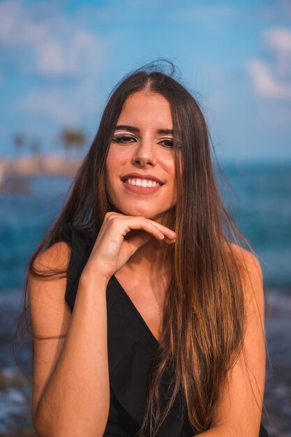 Portret młodej kobiety brunetka korzystających z jej dnia na wybrzeżu przy plaży