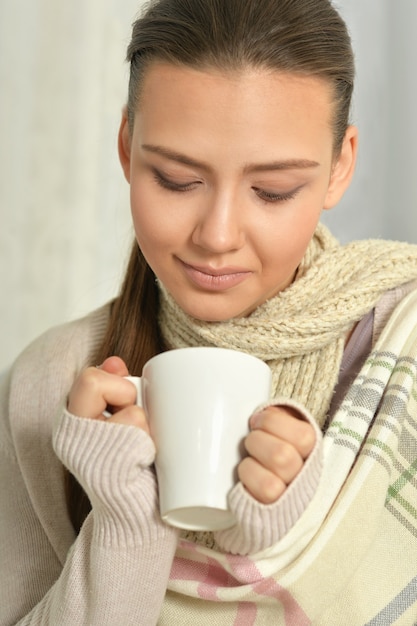 Portret młodej kobiety chorej pijącej gorącą herbatę