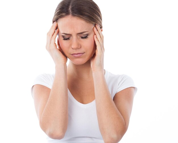 Portret młodej kobiety cierpiącej na ból głowy izolowany na białym