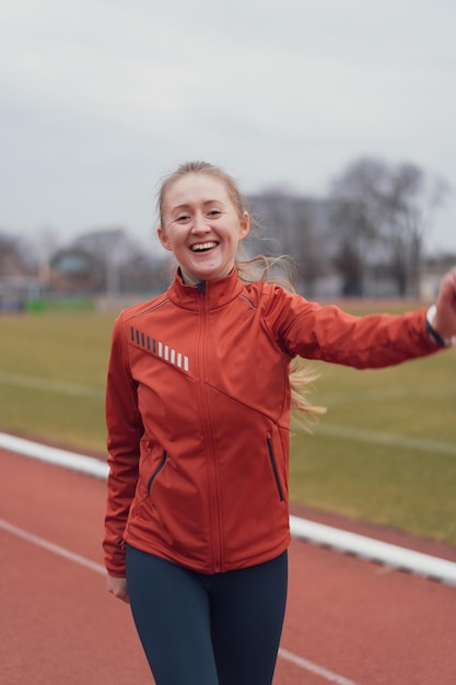 Portret młodej kobiety fitness biegającej na stadionie lekkoatletycznym