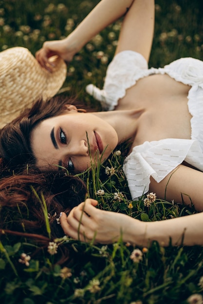 Portret młodej kobiety leżącej w trawie