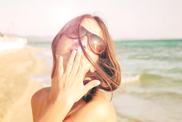 Portret młodej kobiety na plaży na tle nieba