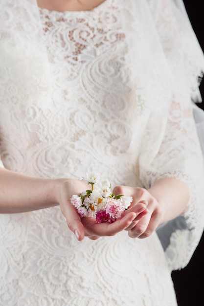 Portret młodej kobiety na ślubnym zdjęciu Fryzura ślubna i jasny makijaż Elegancki biały kwiat w jej rękach