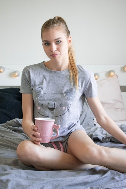 Portret młodej kobiety pijącej kawę w domu