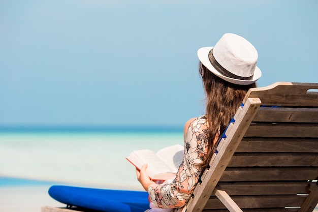 Portret młodej kobiety relaks na plaży, czytając książkę