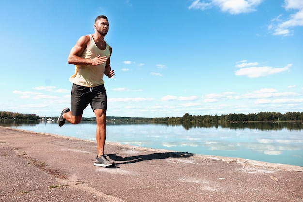 Portret młodej kobiety sprawny i sportowy robi rozciąganie na świeżym powietrzu.