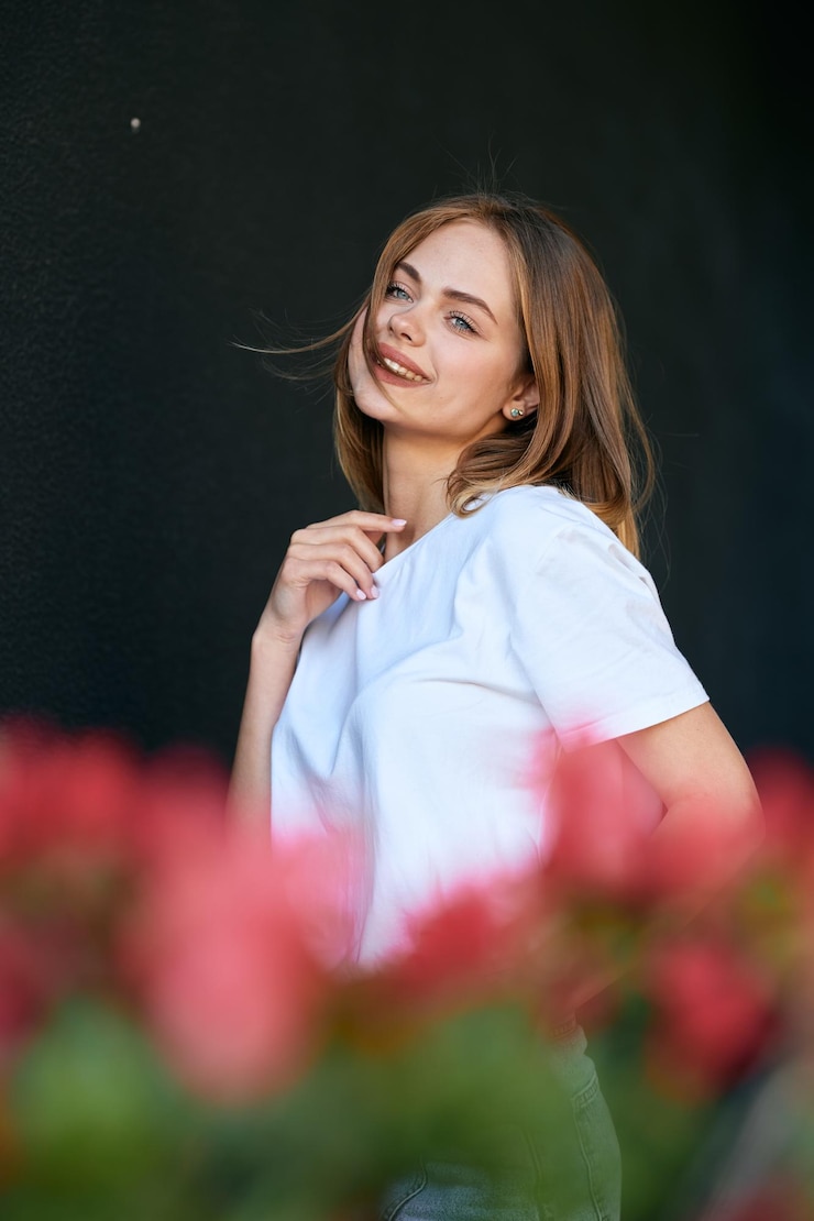 Zdjęcie portret młodej kobiety stojącej na tle nieba
