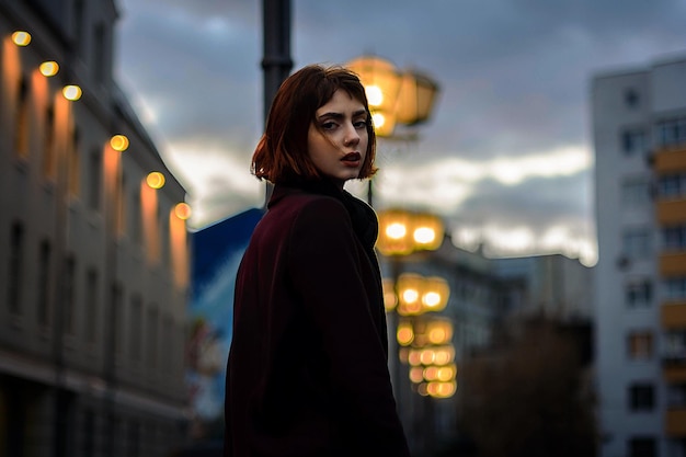 Portret młodej kobiety stojącej w oświetlonym mieście