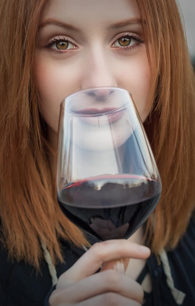 Zdjęcie portret młodej kobiety trzymającej czerwone wino w szklance