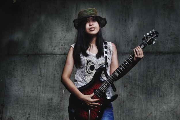 Zdjęcie portret młodej kobiety trzymającej gitarę