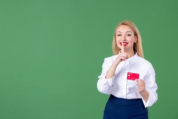 portret młodej kobiety trzymającej kartę kredytową w zielonej ścianie nauczyciel banku pieniędzy