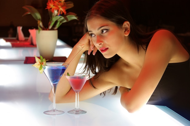 Portret młodej kobiety w barze koktajlowym