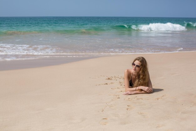 Portret młodej kobiety w białym bikini na tropikalnej plaży patrząc na kamery Piękna latynoska dziewczyna w strojach kąpielowych z miejsca na kopię