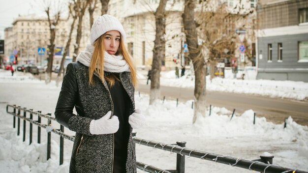 Portret młodej kobiety w ciepłych ubraniach w mieście w zimie