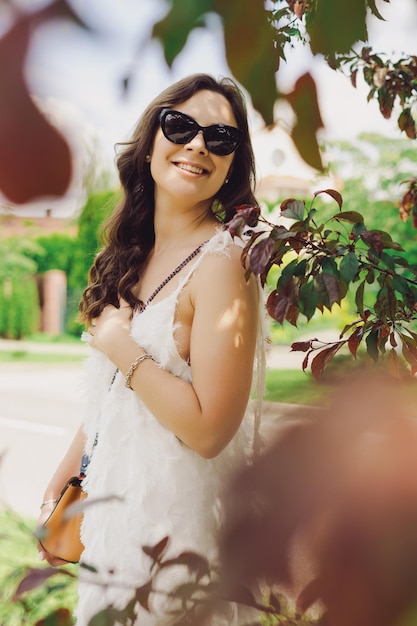Portret młodej kobiety w letni dzień Modelka w białej sukni pozuje na zewnątrz