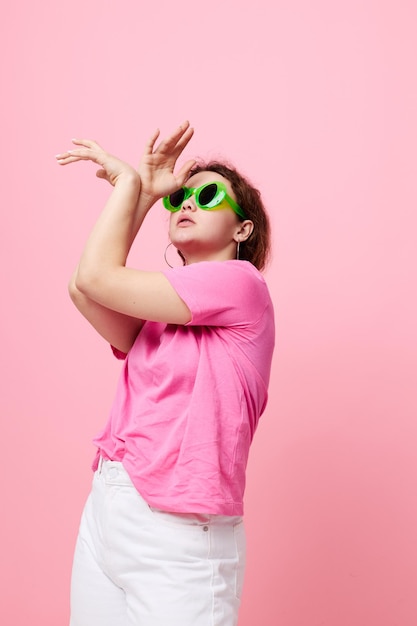 Portret młodej kobiety w różowej koszulce w zielonych okularach Studio mody młodzieżowej