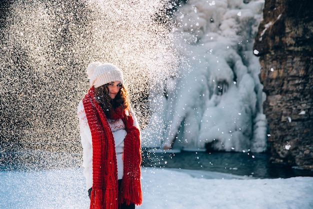 Portret młodej kobiety w śniegu z szalikiem, która próbuje się ogrzać Zimowa koncepcja