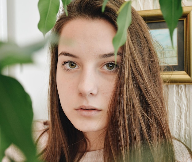 Portret młodej kobiety w zbliżeniu do rośliny